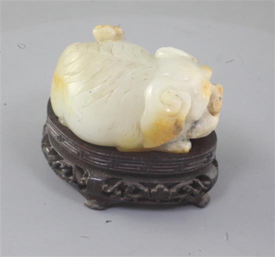 An unusual Chinese pale celadon and russet skin jade lion-dog snuff bottle, 19th century, length 5cm excl. wood stand